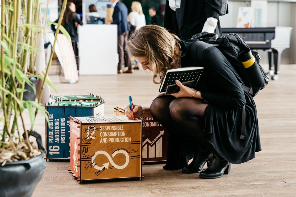 Woman writing on a 3D model of a sustainable development goal at the 2019 european b corp summit